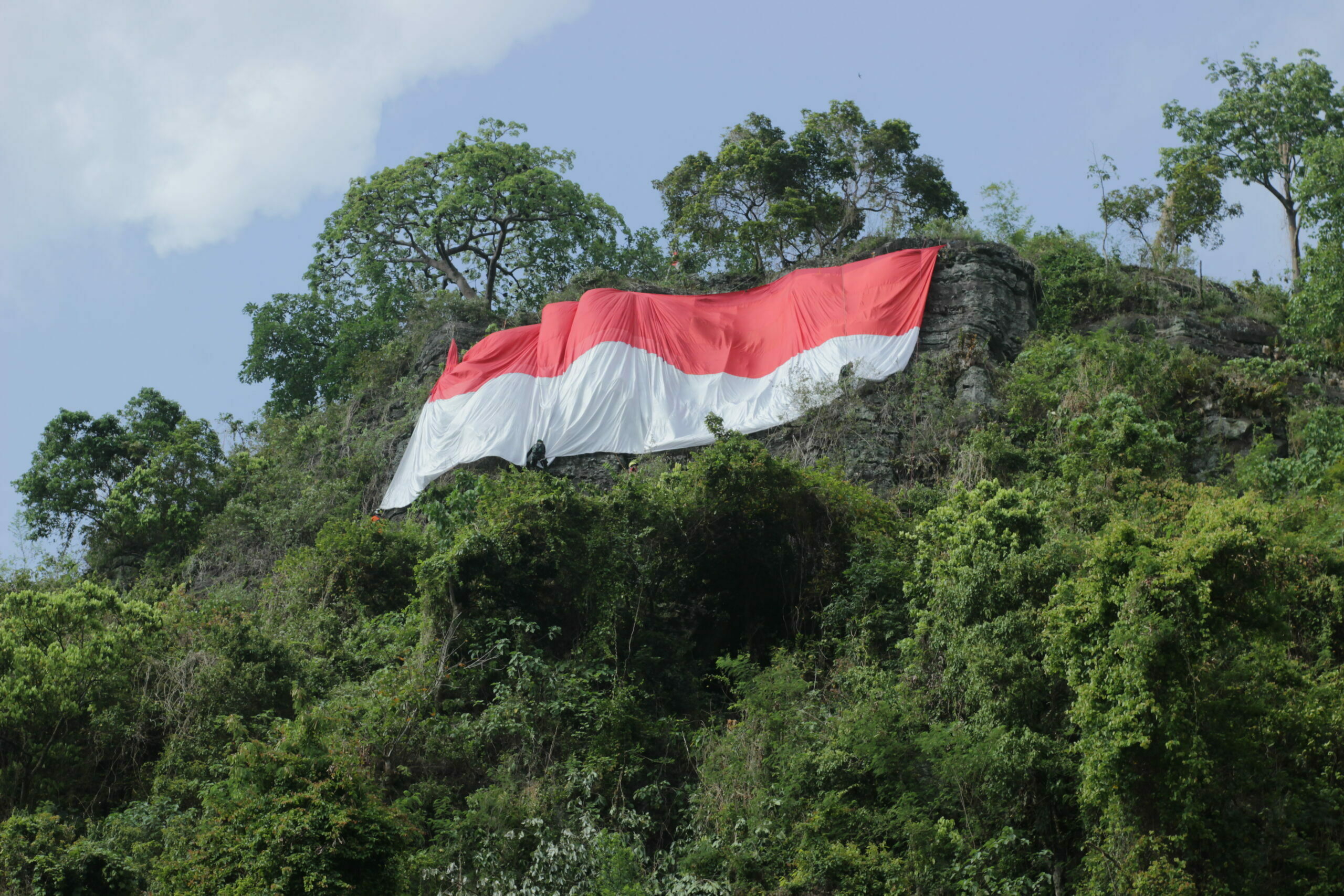 Berkibarnya Bendera Raksasa di Tebing Sepago